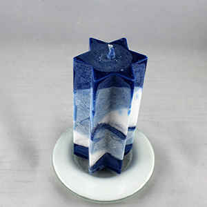 Sechsstern Stearinkerzen auf blauem Glasteller